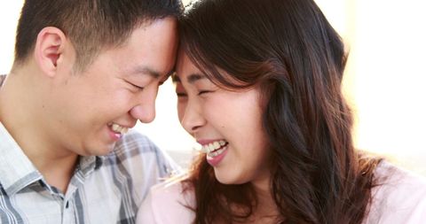 Happy Asian Couple Sharing Laughter in Close Embrace
