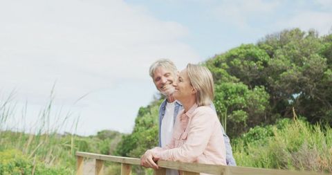 Happy Senior Couple Embracing Outdoors Amid Nature