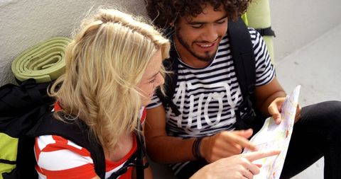 Young tourists planning next travel adventure with map