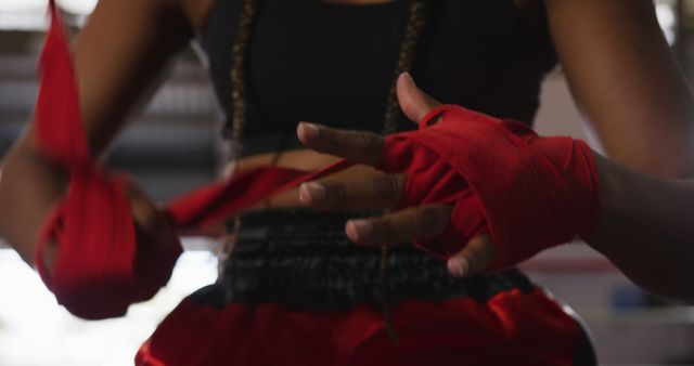 Focused Female Boxer Wrapping Hands with Red Bandages in Gym - Download Free Stock Images Pikwizard.com