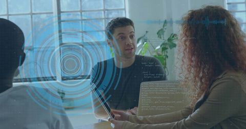 Young professionals discussing digital interface with holographic hud overlay during meeting