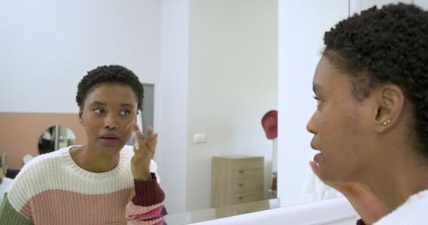 Woman Practicing Self-Care in Modern Bathroom Mirror