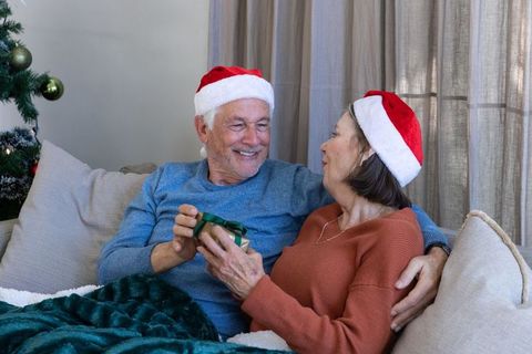 Senior Couple Exchanging Christmas Gift with Joyful Expressions