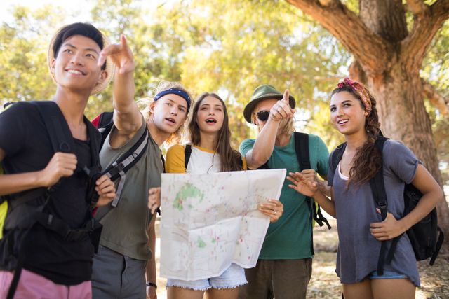 Group of friends hiking in nature, using a map to navigate their route. Ideal for themes related to outdoor activities, adventure travel, teamwork, and friendship. Perfect for promoting hiking gear, travel destinations, or outdoor adventure experiences.