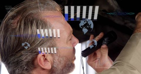 Senior technician inspecting machinery with handheld probe and futuristic hud data analytics overlay