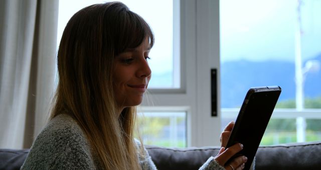 Young Woman Reading Digital Book on Tablet in Cozy Living Room - Download Free Stock Images Pikwizard.com