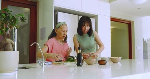 Mother and daughter preparing meal together in modern kitchen