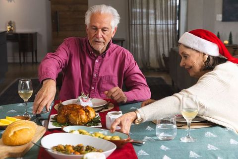 Senior Couple Enjoying Holiday Dinner with Roasted Chicken and Wine