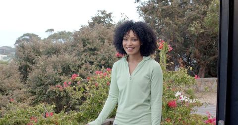 Smiling Woman in Scenic Garden with Lush Greenery and Flowers