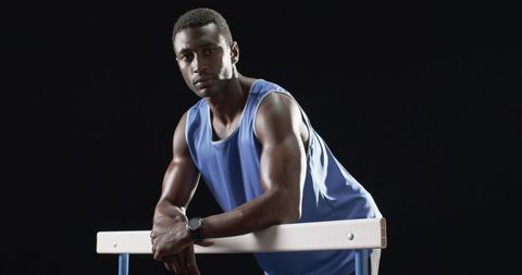 Determined Athlete in Blue Sportswear Leaning on Hurdle - Download Free Stock Images Pikwizard.com