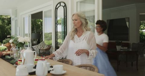 Elegant decoration for wedding with mature woman preparing cozy space