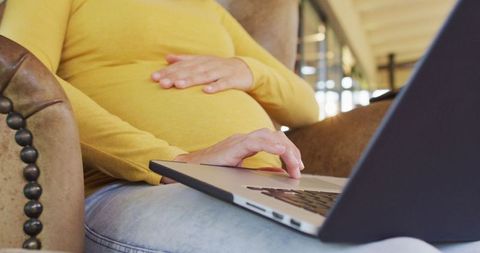 Pregnant Woman Relaxing with Laptop in Cozy Home Setting