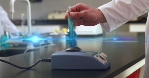 Hand mixing chemical in laboratory test tube shimmering effects