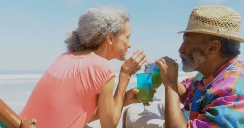 Mature Couple Enjoying Cocktails at Sunny Beach