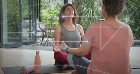 Middle-aged women practicing mindful meditation on sunlit patio with yoga mats and tech overlay