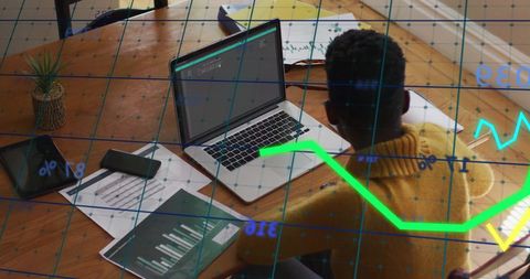 Financial Analyst Working on Laptop with Global Data Graphics