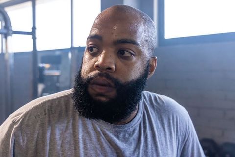 African american man perspiring and focusing during intense indoor gym workout