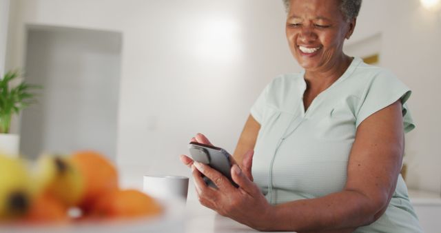 Senior African American Woman Using Smartphone at Home Smiling - Download Free Stock Images Pikwizard.com