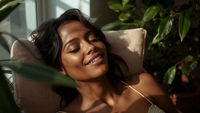Smiling woman relaxing in sun-drenched sunroom basking in blinds light among lush plants