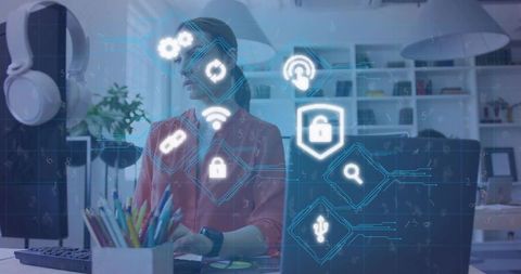 Woman working on laptop with cybersecurity holograms in modern office workspace