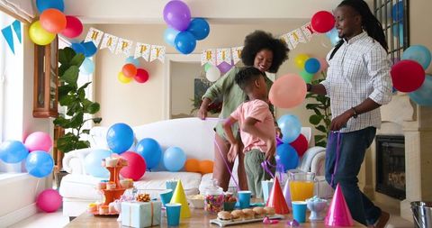 Family Decorating Room for Child's Birthday Party Celebration