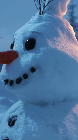 Panning Vertical Video Showing Cozy Three-Tier Snowman at Dusk with Lantern Light