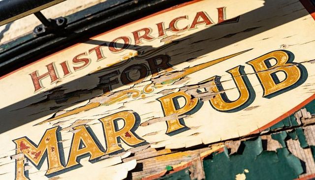 Weathered historical mar pub wooden sign peeling paint rustic lettering