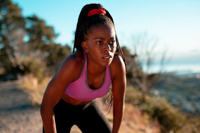 Athletic African American woman engaging in outdoor exercise during sunset. Perfect for promoting healthy living, fitness routines, and active lifestyle campaigns. Suitable for wellness blog posts, sportswear advertisements, and motivational content.
