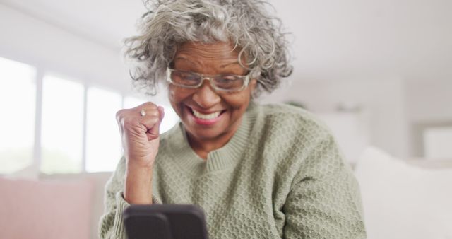 Elderly Woman Celebrating Good News on Smartphone at Home - Download Free Stock Images Pikwizard.com