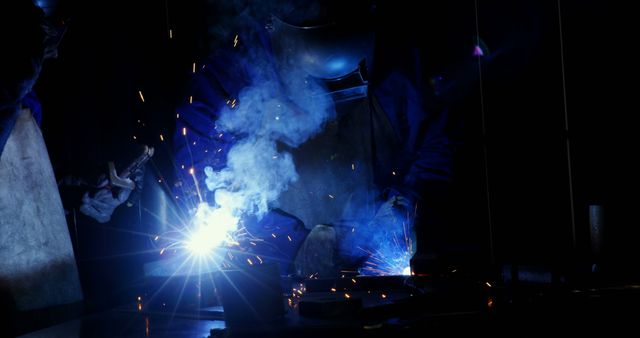 Skilled Welder Working in Dark Workshop with Bright Sparks and Smoke - Download Free Stock Images Pikwizard.com