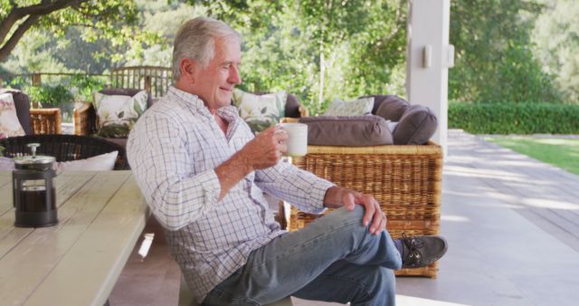 Elderly man enjoying coffee on a porch surrounded by greenery and comfortable furniture, evoking a sense of tranquility and relaxation. Ideal for use in topics related to retirement, self-care, healthy lifestyle, peace, outdoors, and relaxation.