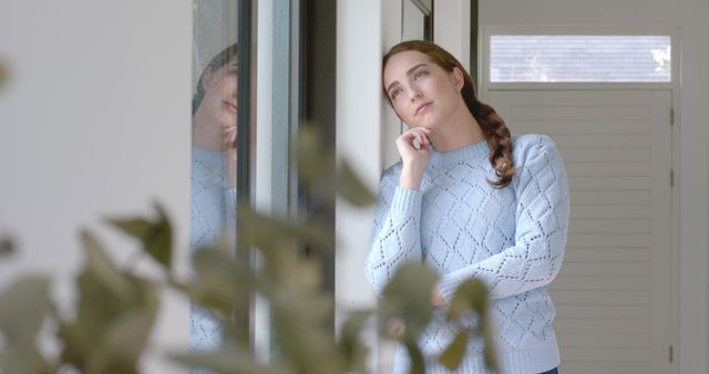 Thoughtful Young Woman Looking Out Window in Cozy Sweater - Download Free Stock Images Pikwizard.com