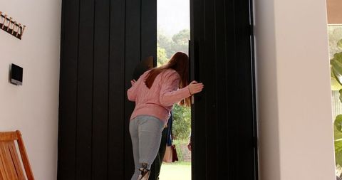 woman opening double door to sunlit backyard in modern home interior - Download Free Stock Images Pikwizard.com