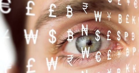 Close-up of eye reflecting global currency symbols