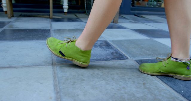 Caucasian woman walking and wearing green shoes in city. City, style, digital nomad and lifestyle.