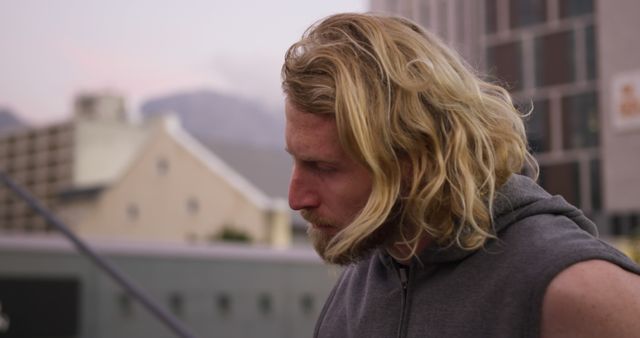 Pensive Bearded Man with Long Blonde Hair Pondering on City Street - Download Free Stock Images Pikwizard.com