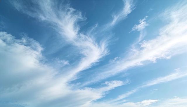 Expansive Blue Sky with Wispy Cirrus Clouds Drifting Across Sunlit Gradient
