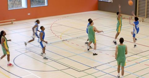 Energetic Basketball Game Between School Teams in Gymnasium