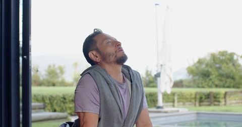 Relaxed Senior Man Stretching on Poolside Patio