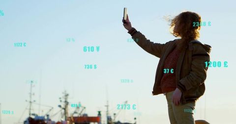 Woman Using Smartphone with Currency Symbols at Fishing Harbor