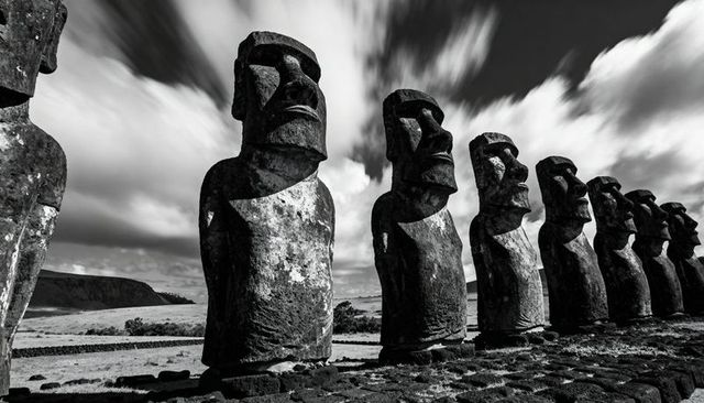Moai guardians standing on rapa nui ahu with dramatic monochrome sky