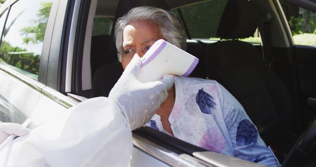 Healthcare Worker Taking Driver Temperature with Infrared Thermometer - Download Free Stock Images Pikwizard.com