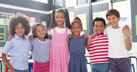 Happy School Children in Classroom Embracing Friendship - Download Free Stock Images Pikwizard.com