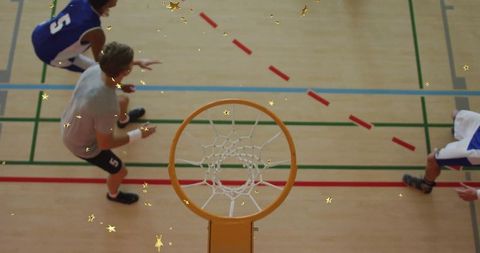 Basketball players competing for rebound on indoor court
