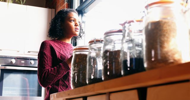 Thoughtful Young Woman Looking Out Kitchen Window - Download Free Stock Images Pikwizard.com