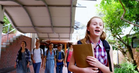 Schoolgirl Smiling and Walking with Friends on Campus