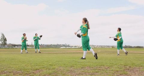 Female softball team engaged in pre-game practice outdoors