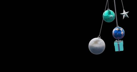 Hanging Christmas Ornaments Against Black Background