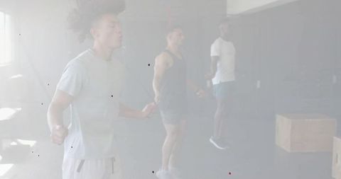 Three men skipping ropes in gym synchronizing cardio and team training session