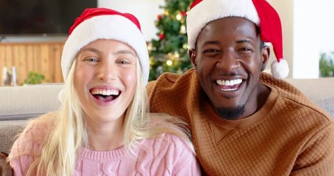 Joyful Couple in Santa Hats Celebrating Christmas at Home